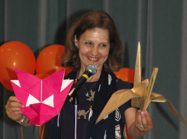 Christine Petrell Kallevig holding an origami paper crane and origami fox